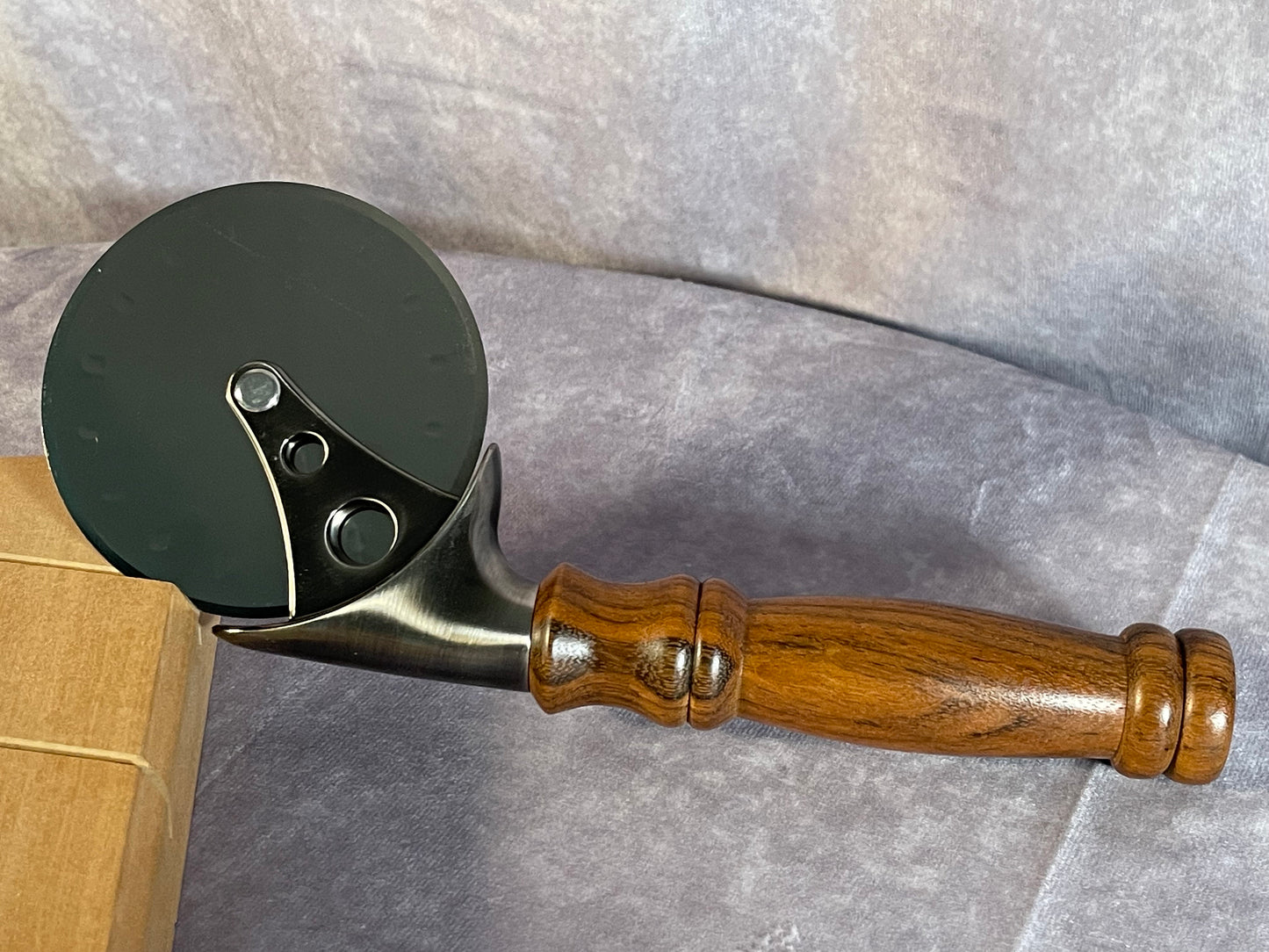 Pizza cutter with handle turned from Monkeypod wood.