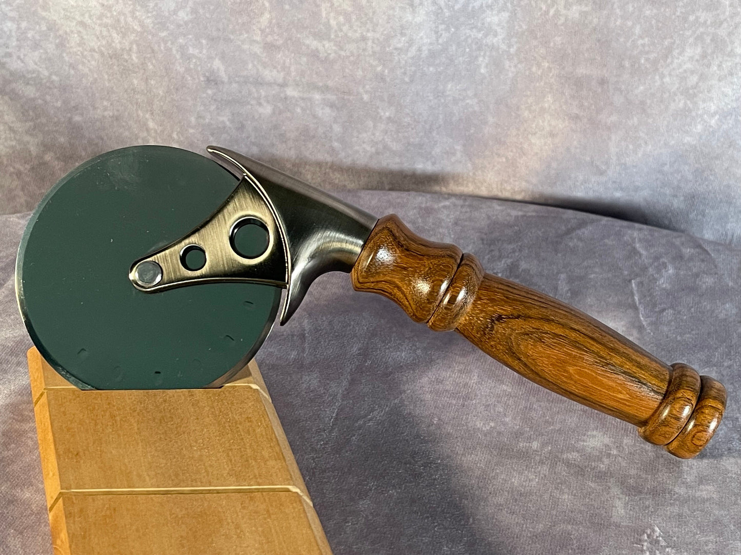 Pizza cutter with handle turned from Monkeypod wood.